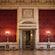 Ornate doors open to a stately room with high ceilings, marble columns and velvet wall paper